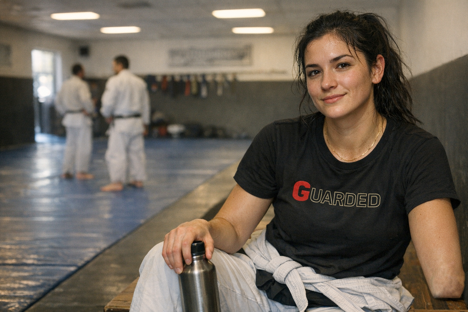 A woman in a jiujitsu academy, a quiet moment after training.